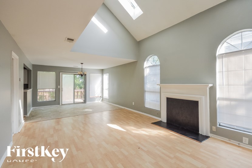 A spacious room with a fireplace and a skylight.