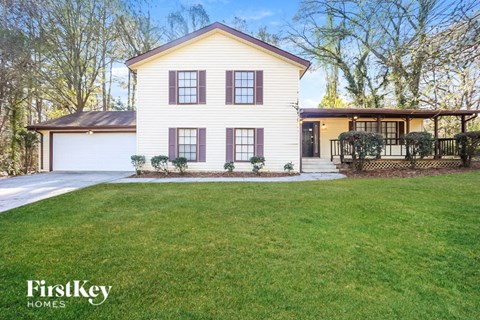 a white house with a lawn and a driveway