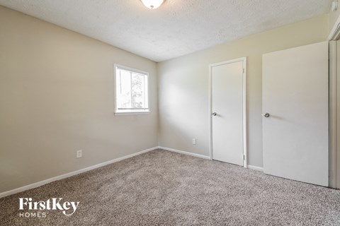 a bedroom with carpet and a door to a closet