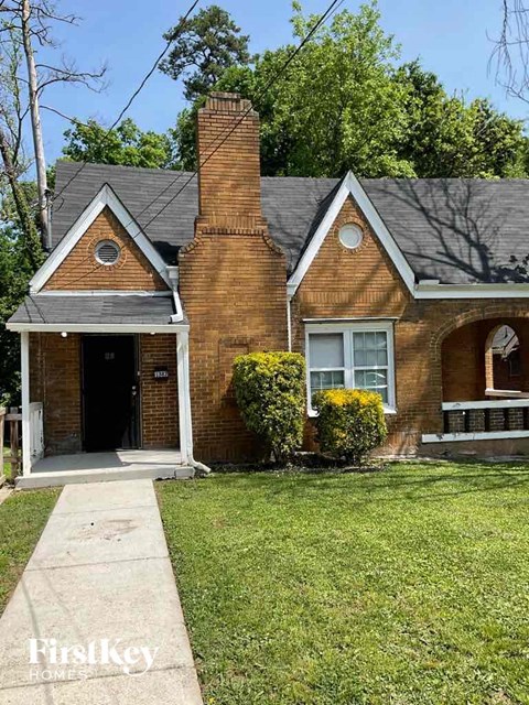 A brick house with a black door and a small porch.