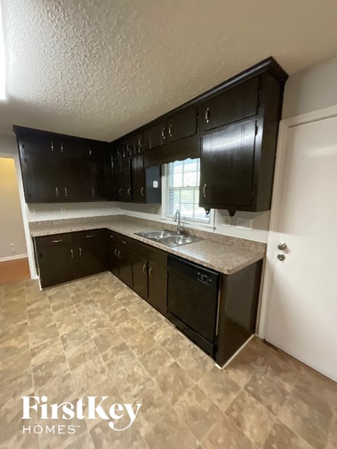 A kitchen with black cabinets and a sink.