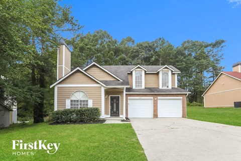 a house with two garage doors and a lawn