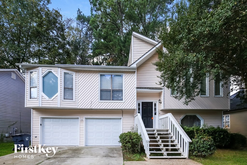 A two-story house with a garage and a driveway.