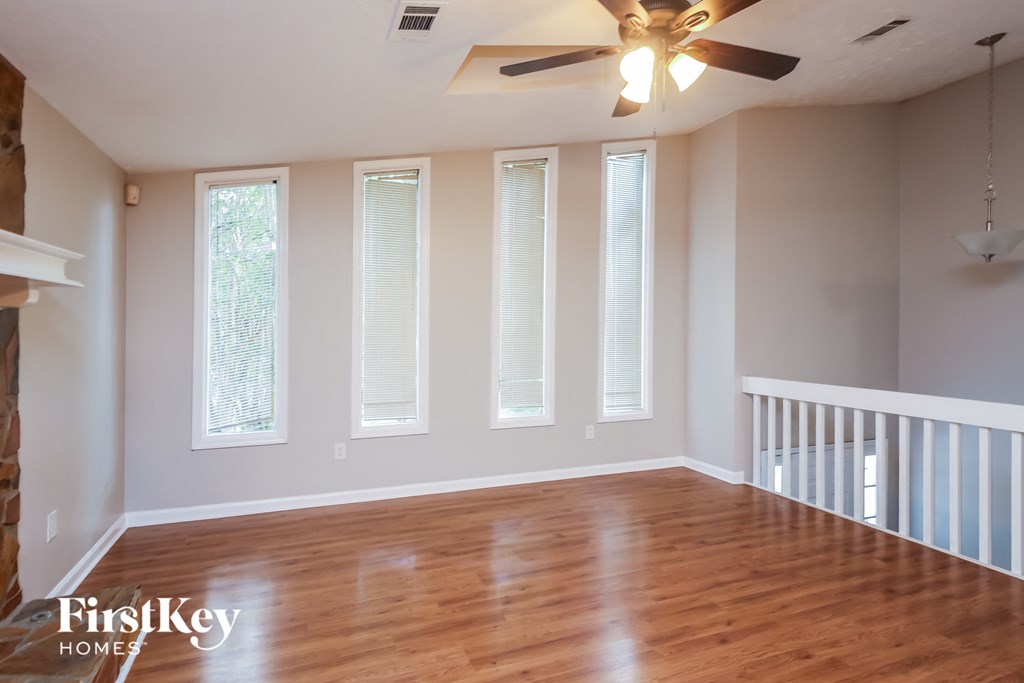 A room with wooden floors and a ceiling fan.