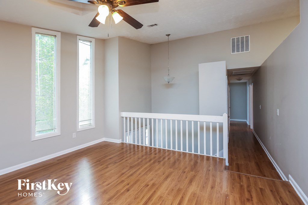 A room with wooden floors and a ceiling fan.