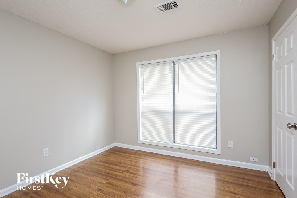 A room with a window and wooden floors.