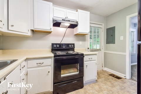 a kitchen with white cabinets and a black stove