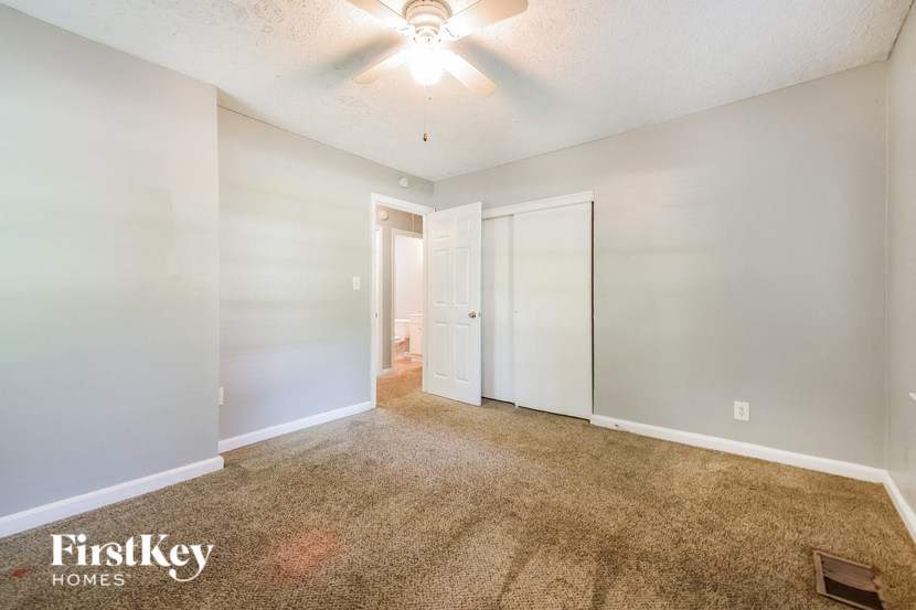 an empty living room with white walls and a ceiling fan