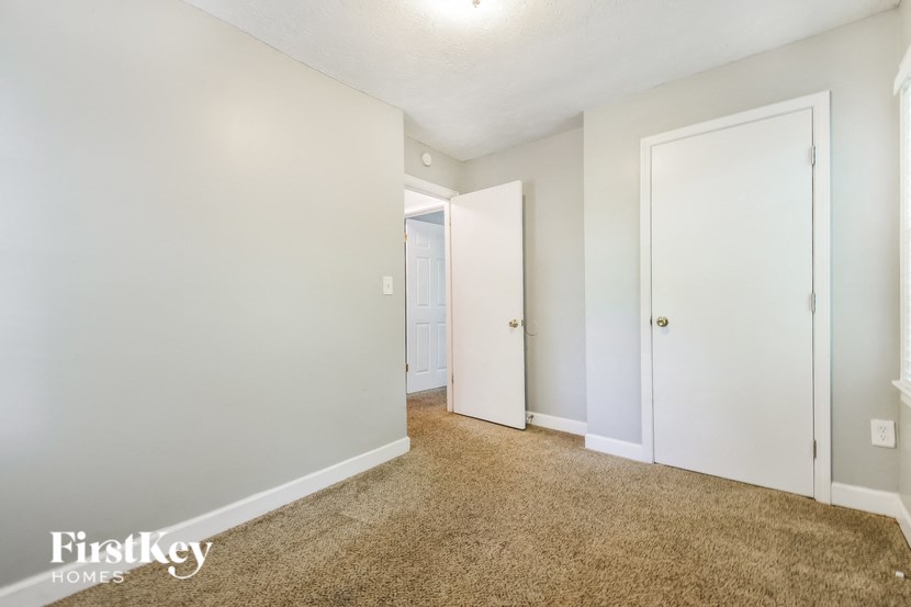 a bedroom with a carpeted floor and white doors