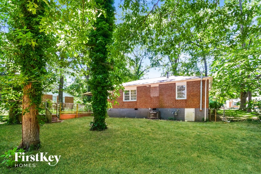 a backyard with a brick house and some trees