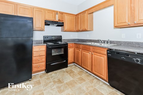 A kitchen with wooden cabinets and black appliances.