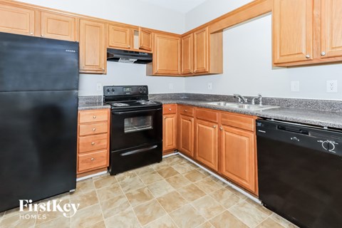 A kitchen with wooden cabinets and black appliances.