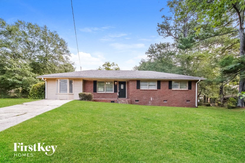 a brick house with a lawn and a sidewalk
