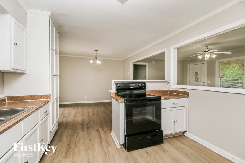 a kitchen with white cabinets and a black stove top oven