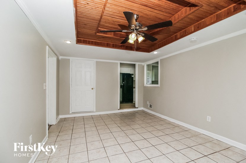an empty living room with a ceiling fan and a tile floor