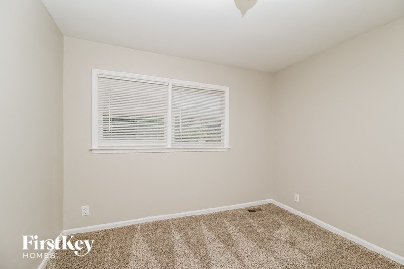 a bedroom with carpet and a window