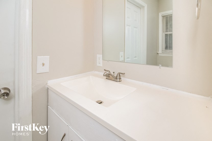 a white bathroom with a sink and a mirror