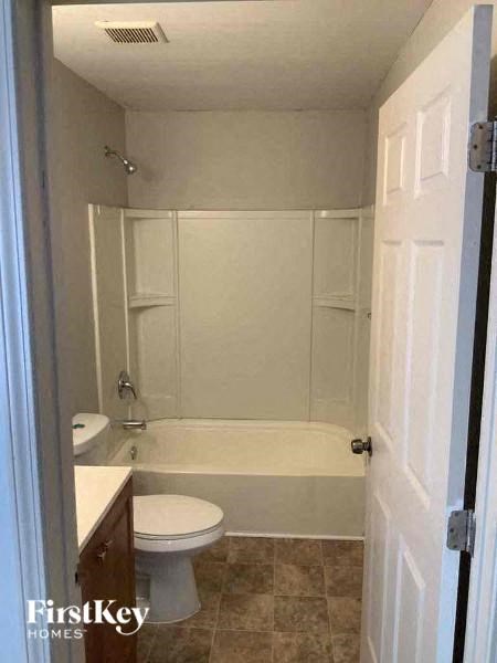 a white bathroom with a toilet and a bath tub