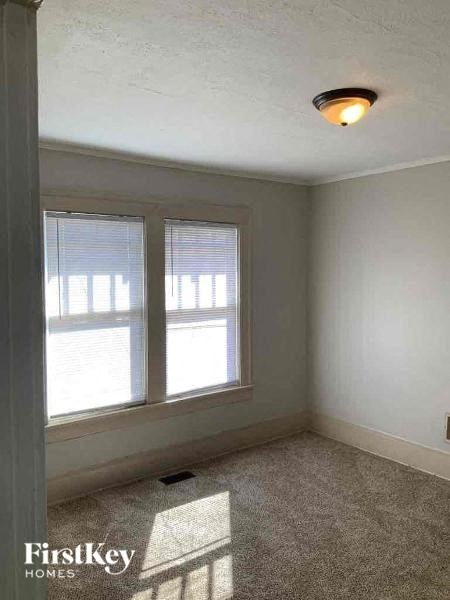 an empty room with two windows and a light on the ceiling