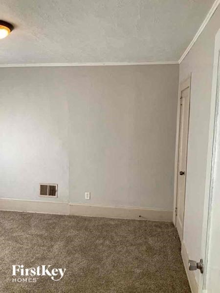 an empty room with a white wall and a door