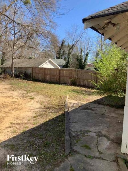 the backyard of a house with a wooden fence