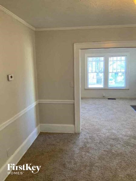 an empty room with a window and a carpeted floor