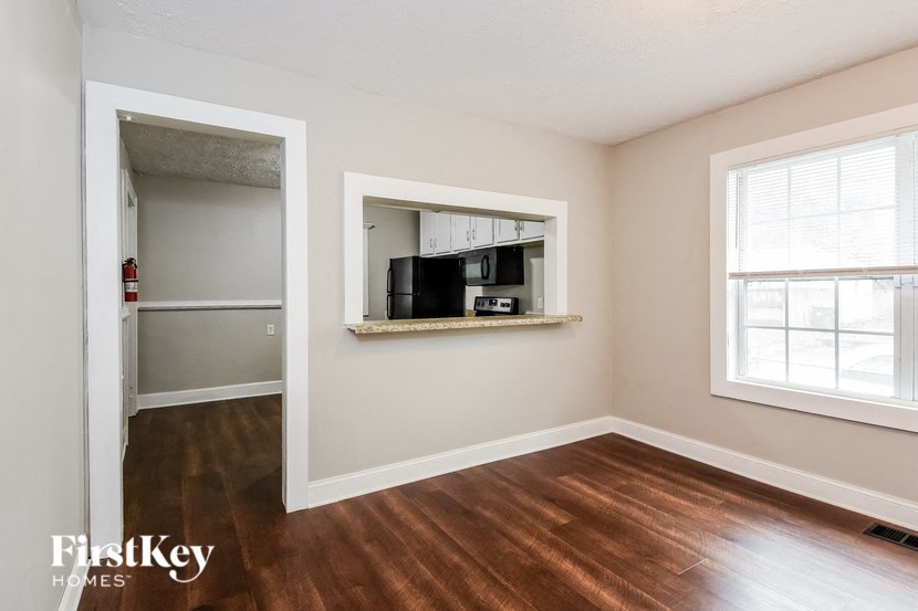 a living room with a hard wood floor and a mirror on the wall