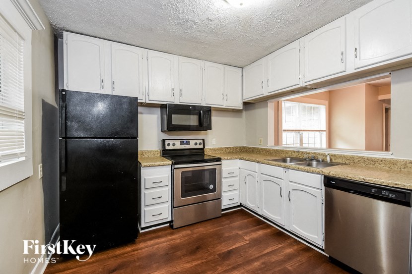 a kitchen with white cabinets and stainless steel appliances