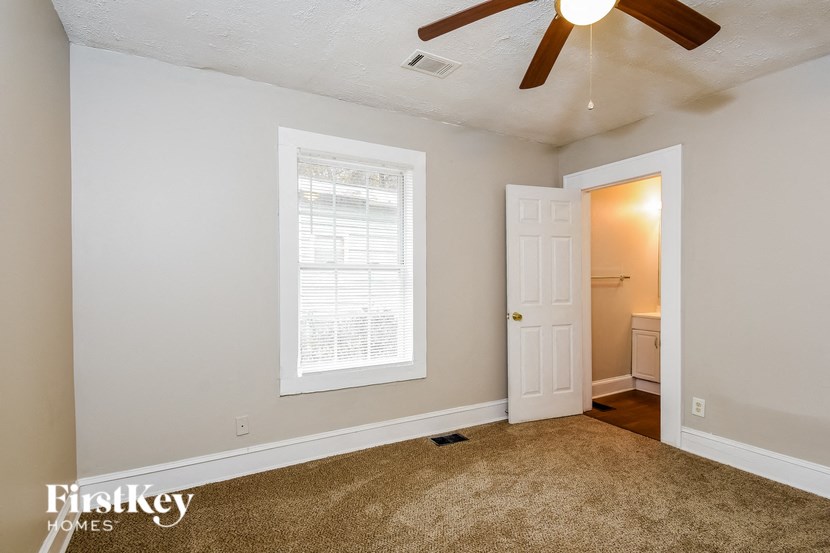a bedroom with a ceiling fan and a white door
