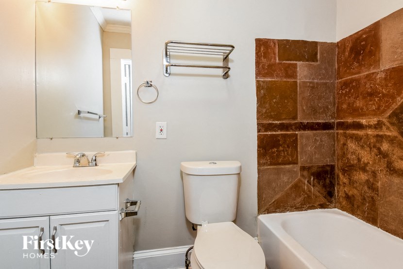 a bathroom with a toilet sink and tub and a mirror
