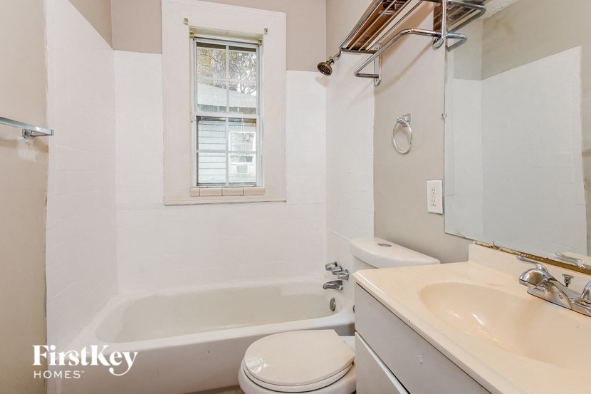 a bathroom with a tub and a sink and a toilet