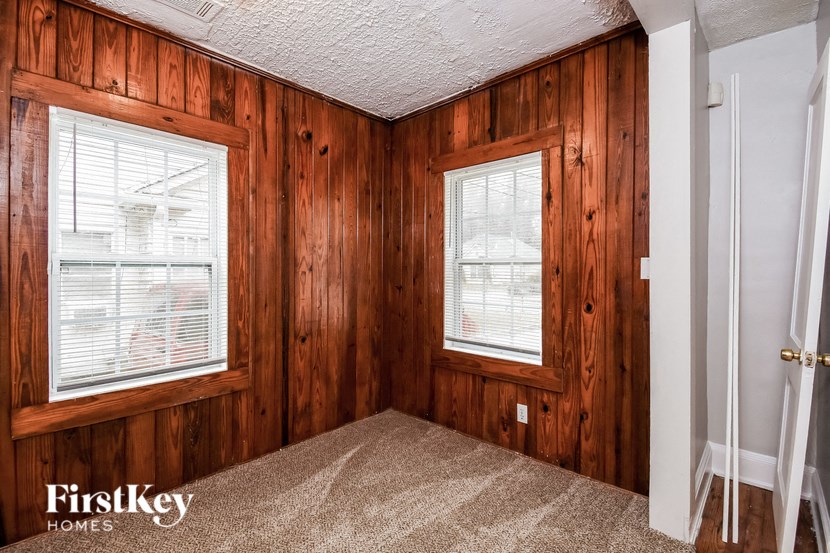 the master bedroom has two windows and a carpeted floor