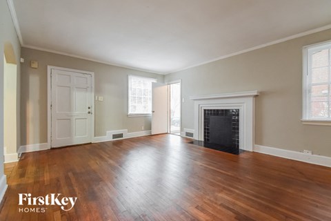 an empty living room with wood floors and a fireplace