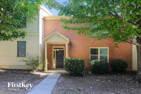 a brick house with a sidewalk in front of it
