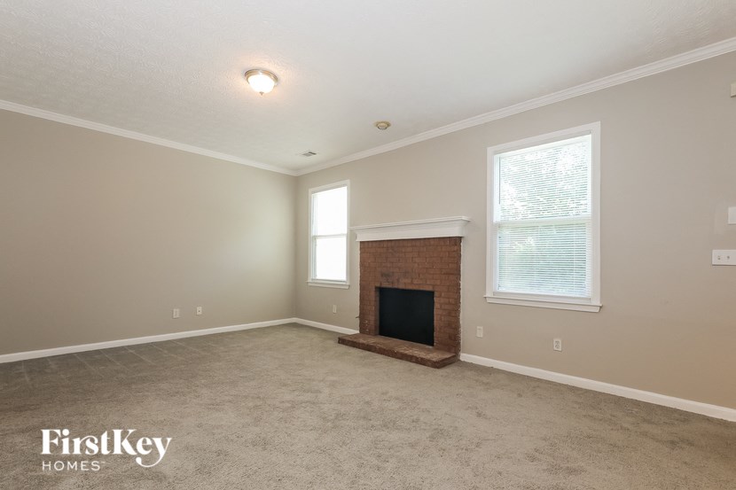 the living room of an empty house with a fireplace