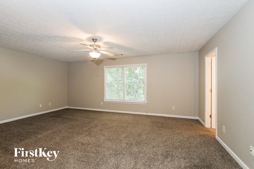 the master bedroom is spacious and updated with carpeting and a ceiling fan