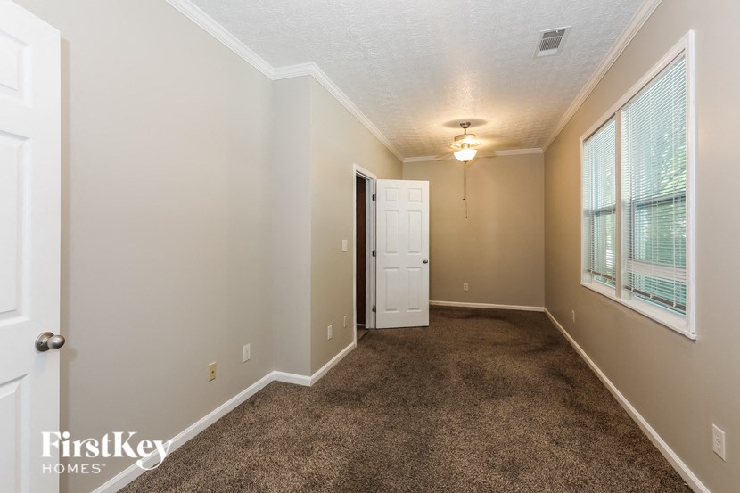 a carpeted living room with a white door and a window