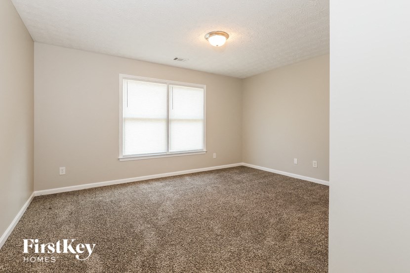 a empty room with carpet and a window