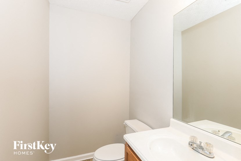 a bathroom with a sink toilet and a mirror