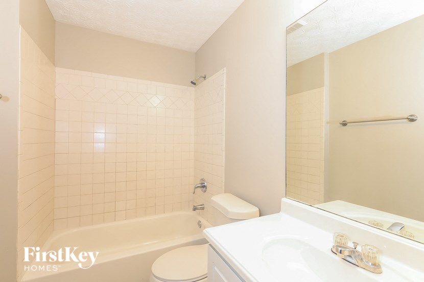 a white bathroom with a tub and a sink and a toilet