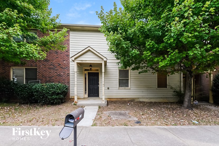 a small white house with a parking meter in front of it
