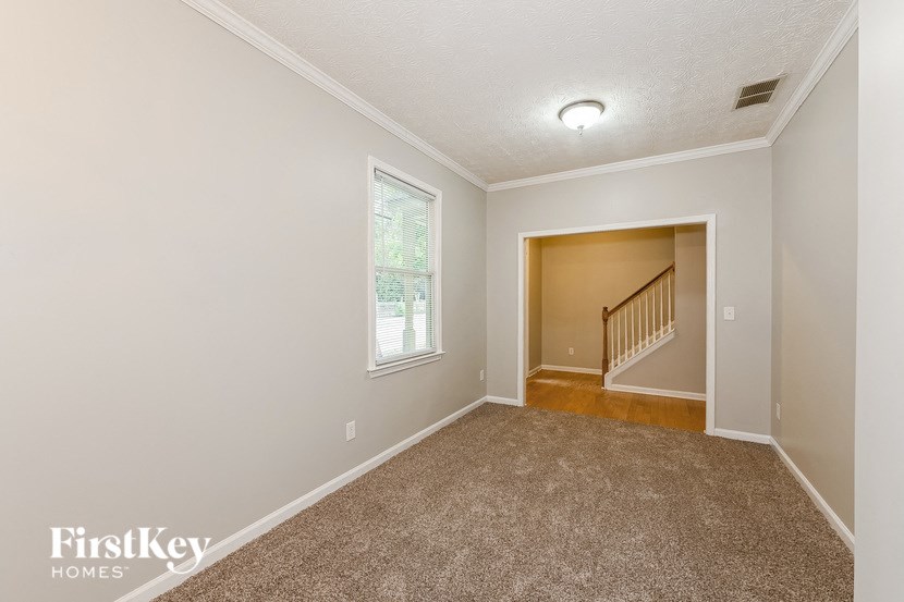 the living room and dining room with carpeting and a window