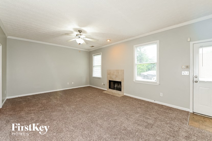 a living room with a fireplace and a ceiling fan