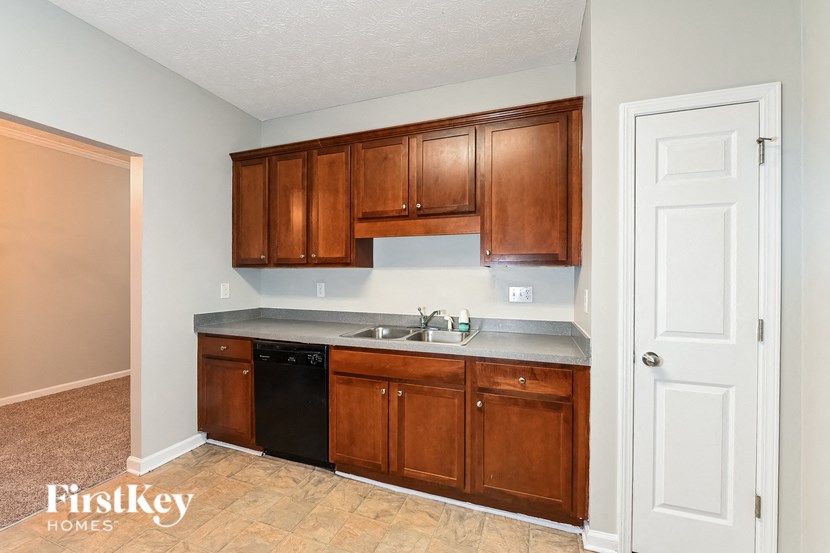 a kitchen with wooden cabinets and a black dishwasher
