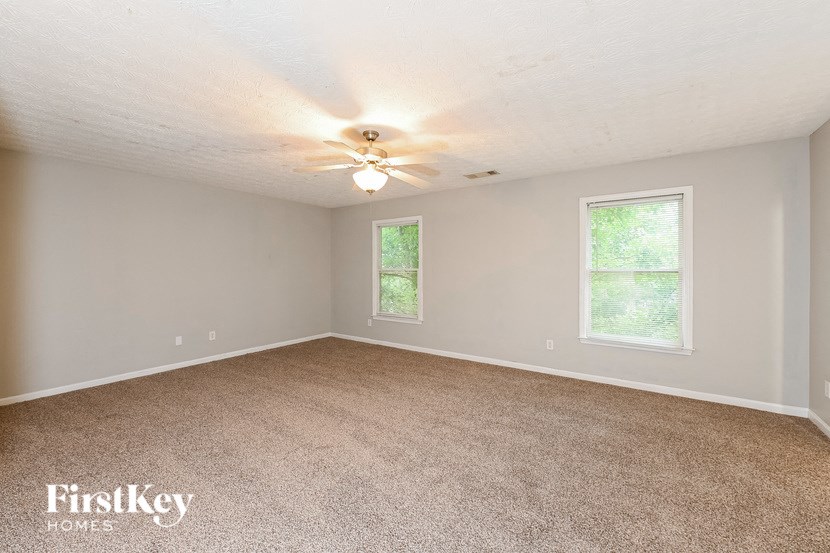 a bedroom with a carpeted floor and a ceiling fan
