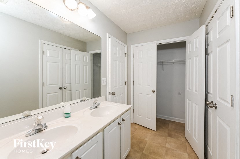 a bathroom with a sink and a mirror and a closet