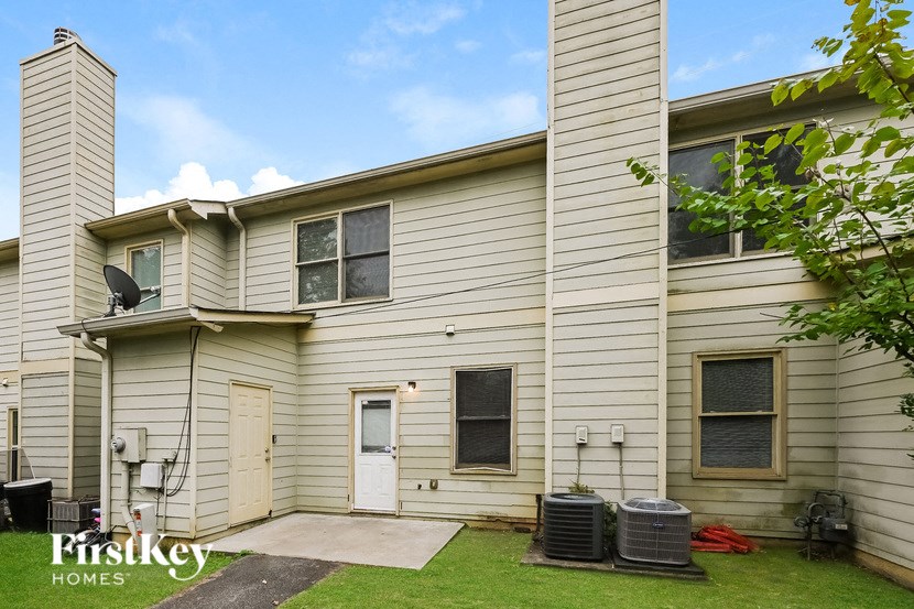 the outside of a white house with a yard and a white door