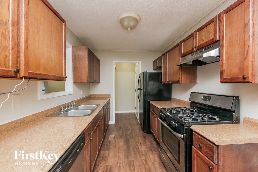 a kitchen with wooden cabinets and a black stove and refrigerator
