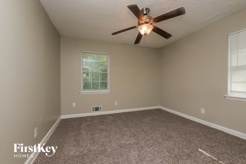 a bedroom with carpet and a ceiling fan