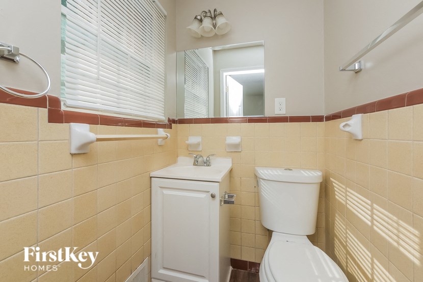 a bathroom with a toilet and a sink and a mirror